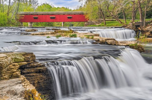 Waterfall with red bridge over it