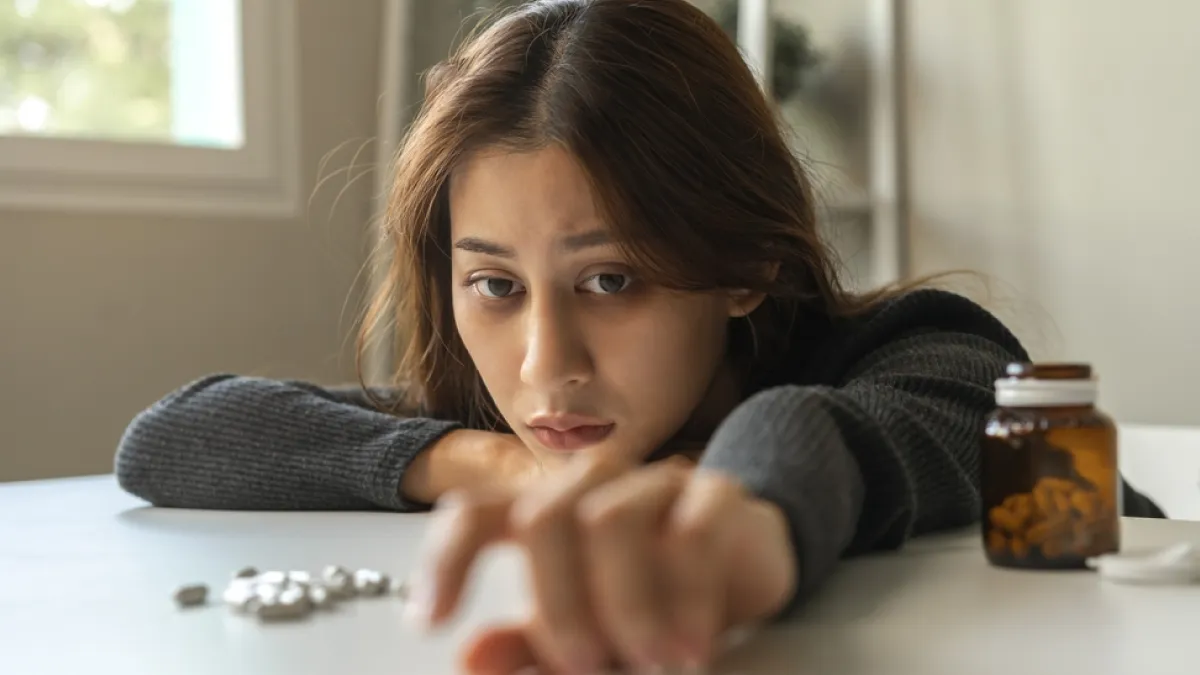 Young woman reaching for illicit pills. The number of opioid overdose deaths involving alcohol rose by 41 percent from 2019 to 2020
