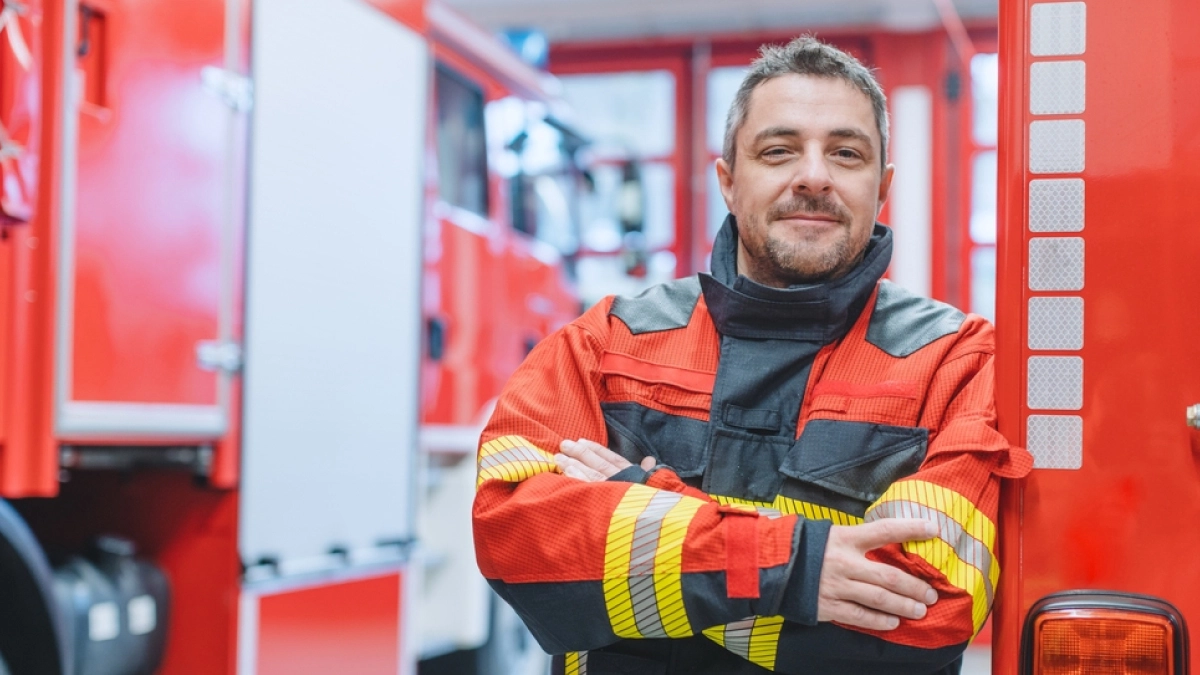 Firefighter smiling. Text explains first responders face unique stressors due to exposure to trauma and high-pressure decision making.