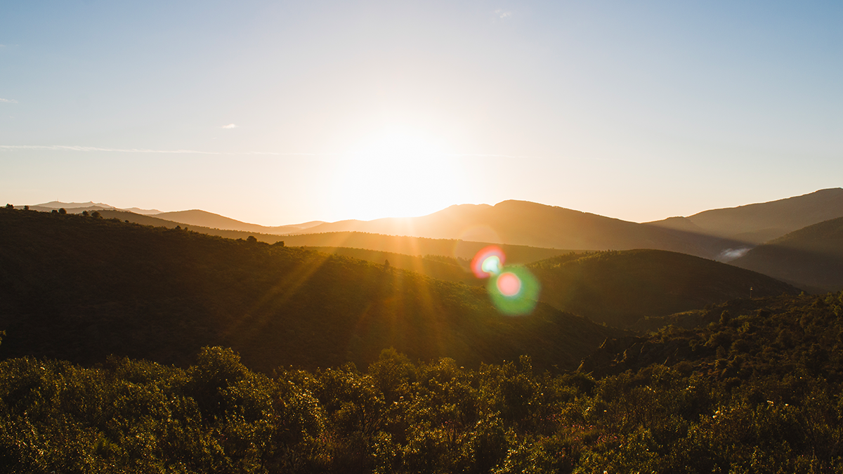 Sunrise over a mountainscape. Natural sunlight and green spaces enhance cognitive functioning and well-being.