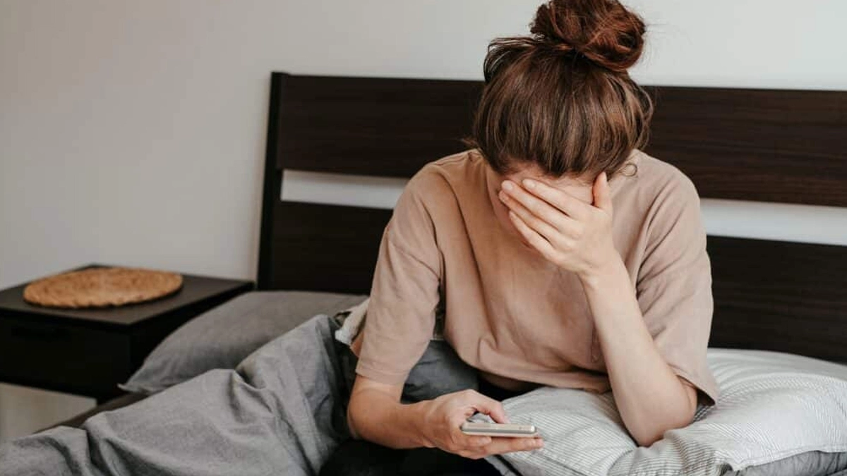 Woman crying looking at a phone.